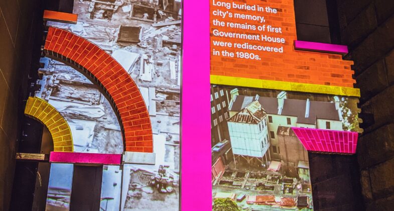 Projected text and photographs on an architectural remnant displayed at the Museum of Sydney, which explains that they are the remains of the the first Government House, long buried in the city's memory, rediiscovered in the 1880's.