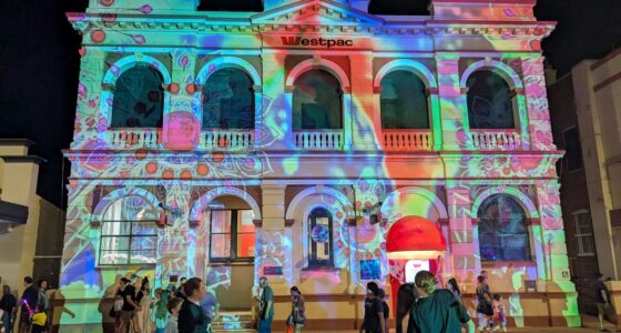 People gather under the evocative Dreamlike projections on heritage buildings at Narrabright street festival.
